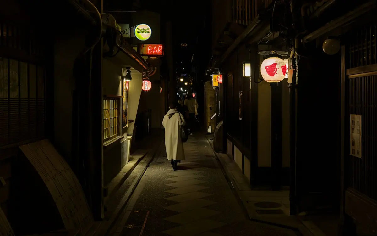 Pontocho lane in the evening with lit lanterns and a pedestrian